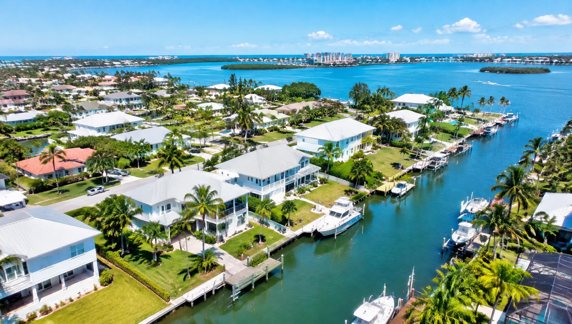Aerial view of a sunny Florida coastal neighborhood with canals